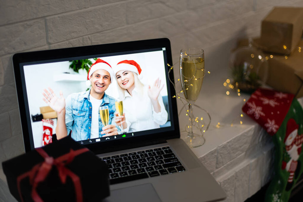 Hymyilevä nainen ja mies video, hän on onnellinen ja haluaa hyvää joulua verkossa, sisustettu huoneen sisustus taustalla - Valokuva, kuva