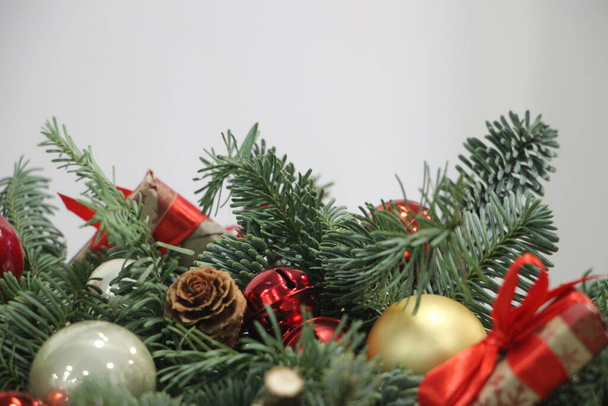 Різдвяні кульки, вафлі, прикраси і подарунок упаковані на гілки ялиці. Новорічна листівка
. - Фото, зображення