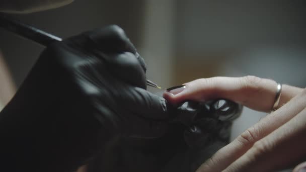 Αρσενικό μανικιούρ - ο πελάτης κάνει ένα μινιμαλιστικό μαύρο σχέδιο στα νύχια του από τον πλοίαρχο στο στούντιο - Πλάνα, βίντεο