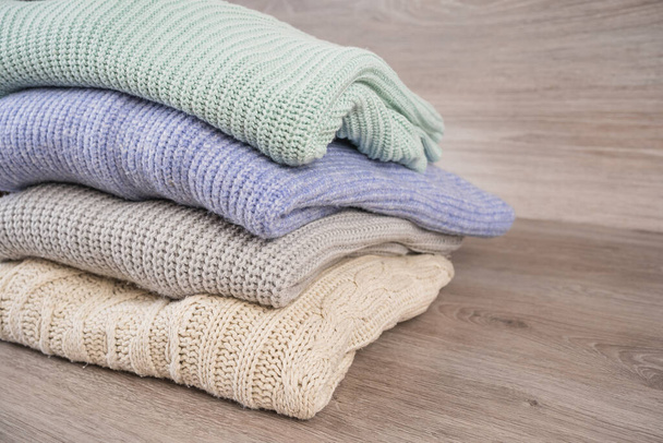 a stack of warm cozy woolen sweaters jersey jumpers for the winter - Foto, Imagem