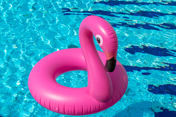 Kesäkonseptin tausta. Vaaleanpunainen puhallettava flamingo uima-altaassa veden kesärannalla tausta. Allasbileet - Valokuva, kuva