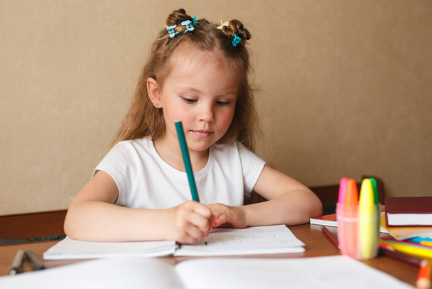 Little girl doing homework writing and reading at home - Foto, Bild