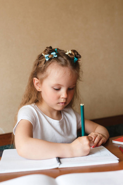 Cute little girl is learning to write at home - Foto, Imagem