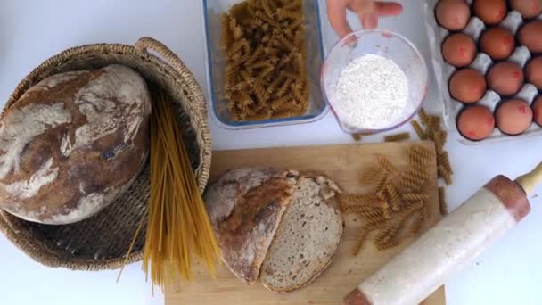 Ψωμί, μακαρόνια και αυγά σε λευκό τραπέζι - Πλάνα, βίντεο