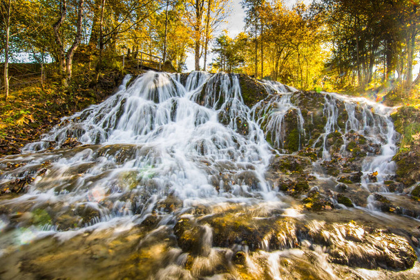 beautiful large waterfall in a warm autumn sun while hiking in the mountains - Fotoğraf, Görsel