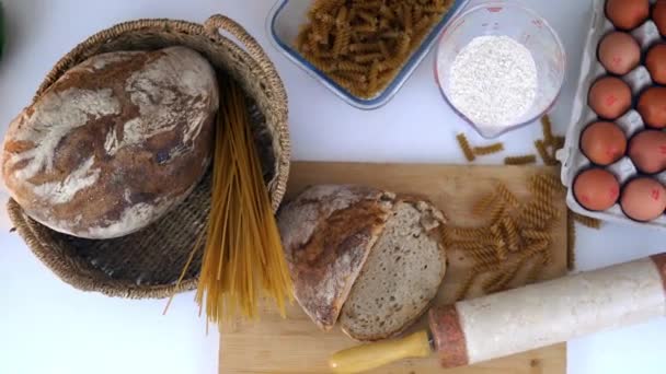 Ψωμί, μακαρόνια και αυγά σε λευκό τραπέζι - Πλάνα, βίντεο