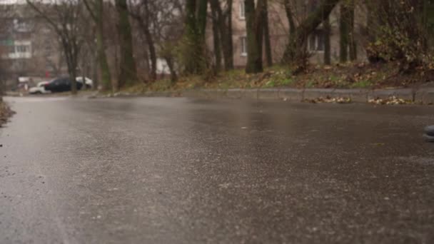 Ghiaccio pesante sulla strada. L'uomo scivola con attenzione sul ghiaccio sulla strada. Pericolosa glassa durante la pioggia gelida. - Filmati, video