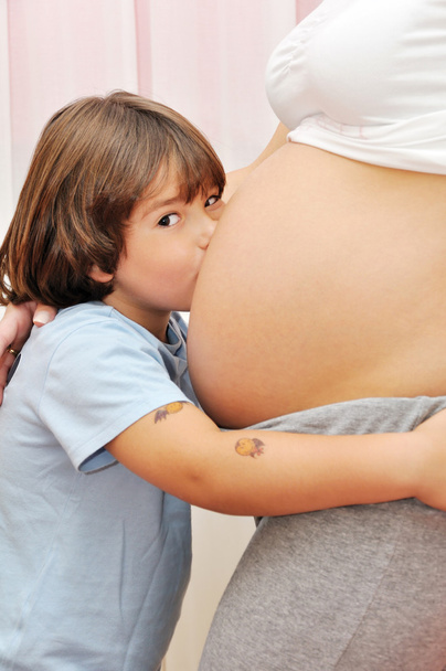 Young boy kissing pregnant belly - Foto, Imagen