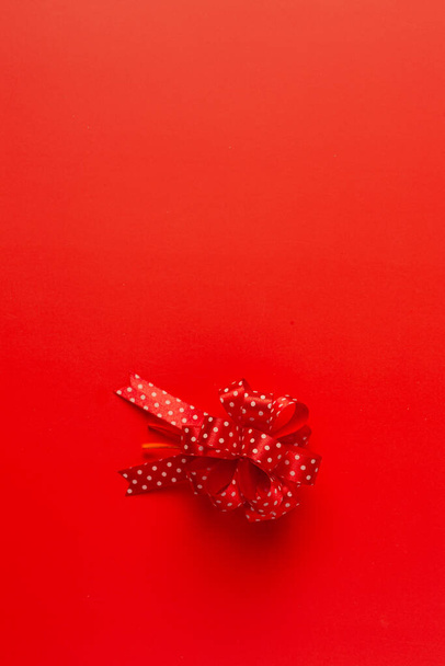 una scatola di regalo con fiocco a nastro rosso su sfondo rosso - Foto, immagini
