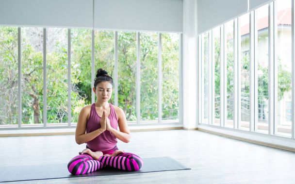 Aziatische vrouwen workout oefenen yoga training zetten roze kleren en praktijk meditatie wellness levensstijl en gezondheid fitness concept in een sportschool, kopiëren ruimte  - Foto, afbeelding