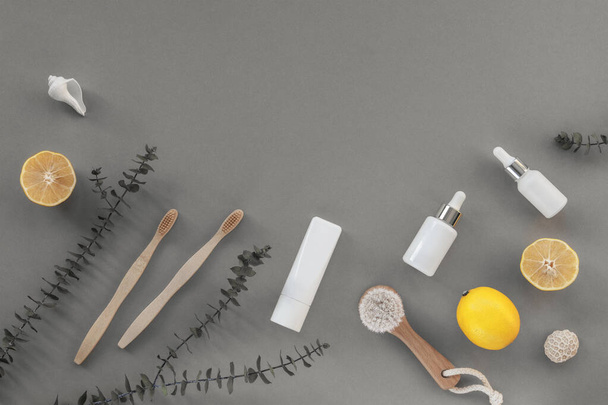 Wooden face brush, cosmetic oil and toothbrushes. Eco-friendly cosmetics and accessories, yellow lemon fruits. Top view, flat lay, copy space. Color 2021 Illuminating and Ultimate Gray - Photo, Image