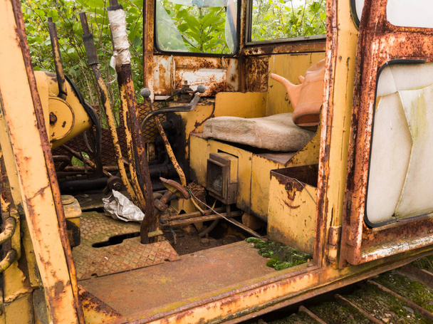 Wnętrze kabiny z dźwignią, joystickiem i siedzeniem opuszczonego starego zardzewiałego buldożera, zabytkowa ciężka maszyna przemysłowa, sprzęt do robót ziemnych, pojazd gąsienicowy - Zdjęcie, obraz