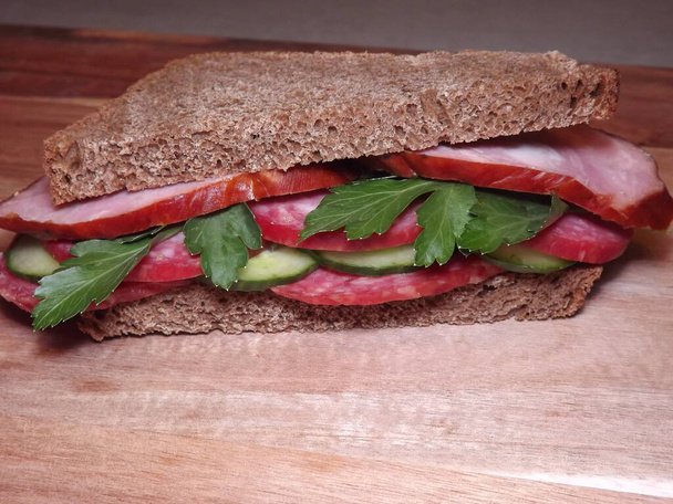 сэндвич с различными видами колбасы и овощей, быстрые закуски - Фото, изображение