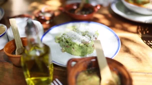 Plonger lentement une puce dans une sauce mexicaine traditionnelle Guacamole sur une table - Séquence, vidéo