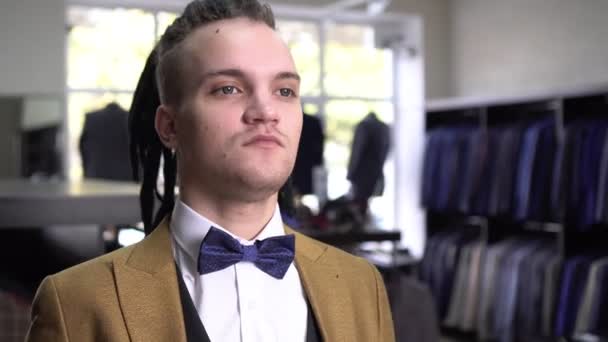 古典的なスーツのスタイリッシュな男と洋服店で弓ネクタイ - 映像、動画