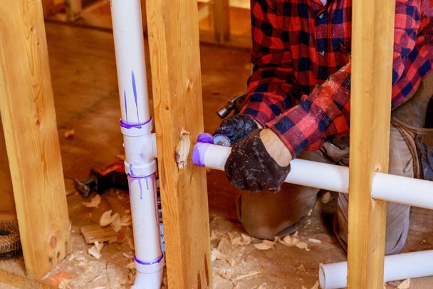 Sanitärunternehmer installiert PVC-Kunststoff-Abflussrohr im Abschnitt für ein Zollhaus - Foto, Bild