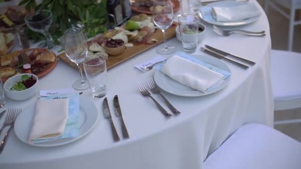 Uma mesa de serviço decorada com um buquê de flores e elegantes cadeiras brancas no banquete de casamento - Filmagem, Vídeo