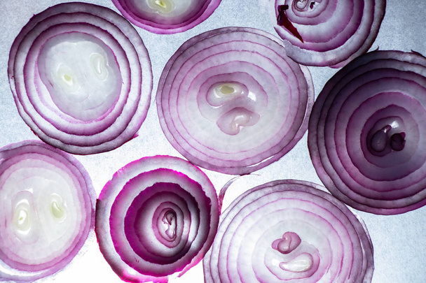 sliced rings of blue onion as background, purple background - Photo, Image