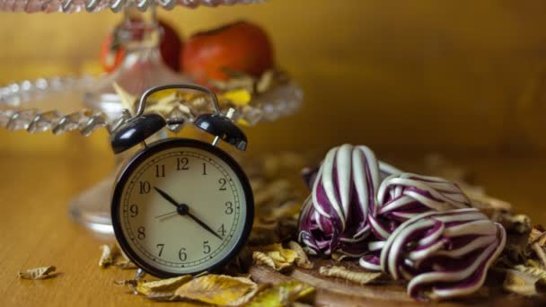 Reloj despertador timelapse con productos típicos de otoño en el fondo  - Metraje, vídeo