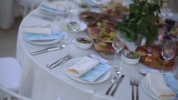 Une table de service décorée d'un bouquet de fleurs et d'élégantes chaises blanches au banquet de mariage - Séquence, vidéo