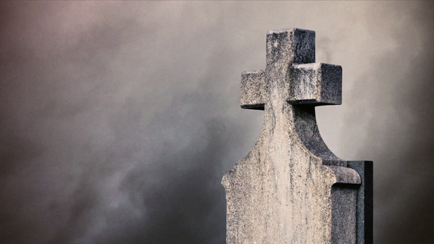 Kruis op de begraafplaats. tijd lapse wolken stroomt langs een steen kruis op een kerkhof. - Video