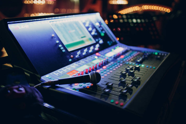 Mixing console and microphone, hand equalizing audio sound channels in night club - Foto, afbeelding