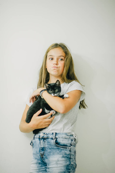 Hübsches junges kaukasisches Mädchen mit niedlichem Kätzchen. Teenager Mädchen mit einem Kätzchen. Ein Kind und eine Katze. Heimtier. - Foto, Bild