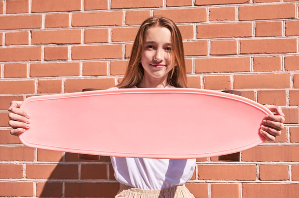 Young woman with skateboard. Pink mockup. Sun shade - 写真・画像