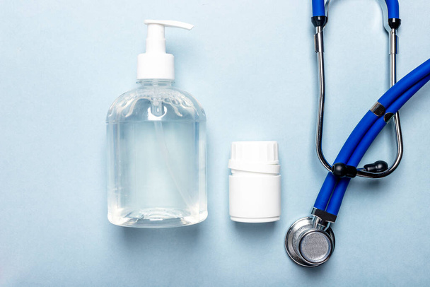 Medical concept, stethoscope, jar of pills and sanitizer bottle, top view, flatlay. - Foto, imagen