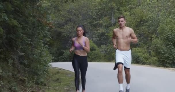 Casal atlético correndo em uma rua, natureza em forma e conceito saudável - Filmagem, Vídeo