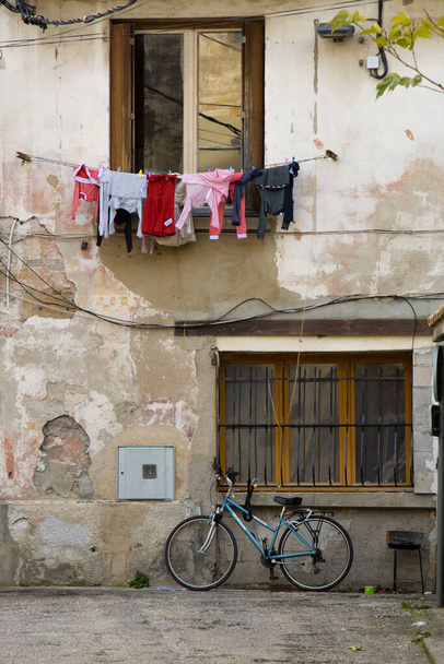 Katu kuva näyttää julkisivu ikkuna ja joitakin vaatteita roikkuu yli polkupyörän - Valokuva, kuva