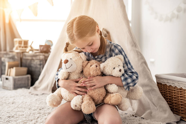 Little girl hugging plush teddies and smiling - Φωτογραφία, εικόνα