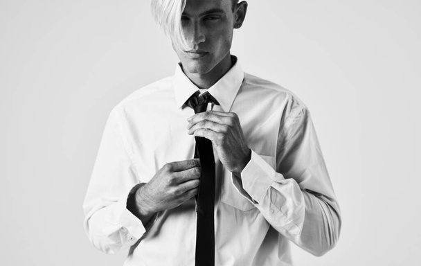 Elegante joven con camisa y corbata sobre un fondo claro recortado ver retrato de cerca - Foto, imagen