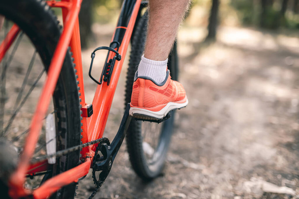Leg in sneaker on bicycle pedal - Foto, afbeelding