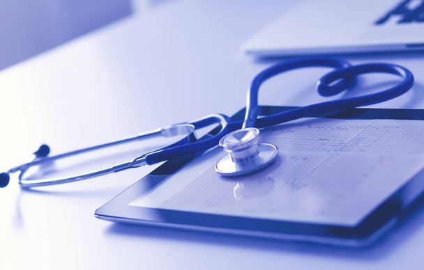 Медицинское оборудование: синий стетоскоп и таблетка на белом фоне. Медицинское оборудование - Фото, изображение