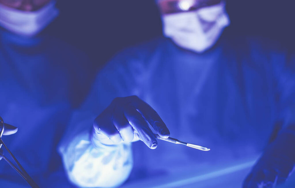 Cropped picture of scalpel taken doctors performing surgery. - Zdjęcie, obraz
