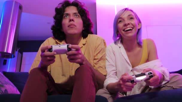 Doma izolovaný. Šťastný pár hraje doma videohry. Mladí lidé se usmívají a smějí, zatímco spolu tráví čas v karanténě. - Záběry, video
