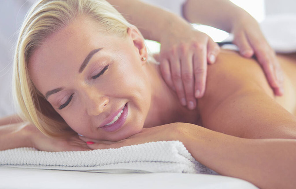 Young woman in spa salon, getting stones massage - Foto, Bild