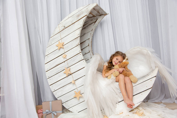 Christmas shooting of a cute little girl in the studio with wings - Фото, зображення