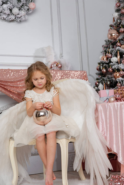 Christmas shooting of a cute little girl in the studio with wings - Valokuva, kuva