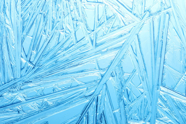 Χειμερινό παγωμένο παράθυρο καλυμμένο με ένα μοτίβο κρυστάλλων πάγου. - Φωτογραφία, εικόνα