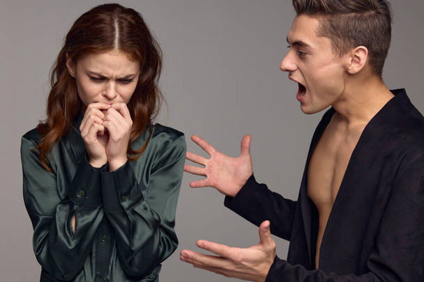 Red-haired woman joined hands near face and aggressive man conflict - Фото, изображение