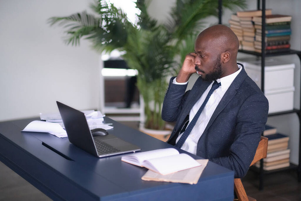 Serious African American Conducts Difficult Phone Negotiations. Head shot pensive young african american international company employee manager working with hard task at workplace. - Photo, Image
