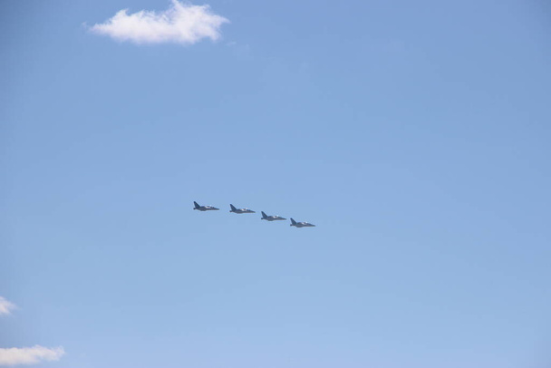 白い雲と青い空に4つの軍事スピットファイア戦闘機シルエット。軍事的概念. - 写真・画像