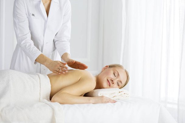 Beautiful caucasian woman enjoying back massage with closed eyes. Beauty and Spa salon concept - Foto, Imagen
