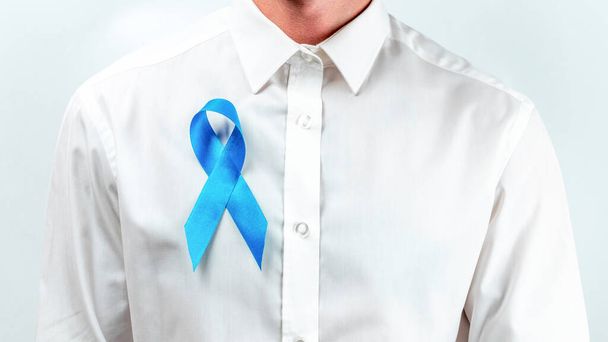 Opieka prostaty. Świadomość prostaty zdrowia mężczyzn w listopadzie. Hipsterzy w jasnej koszuli z niebieską wstążką w rękach na białym tle. Światowy Dzień Raka i koncepcja Światowego Dnia Cukrzycy - Zdjęcie, obraz
