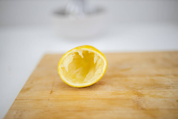 Pelure de citron vide sur une planche à découper avec fond blanc - Photo, image