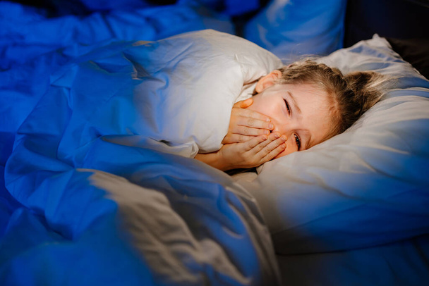 A little girl naps in bed, sees a nightmare in sleep - Fotó, kép