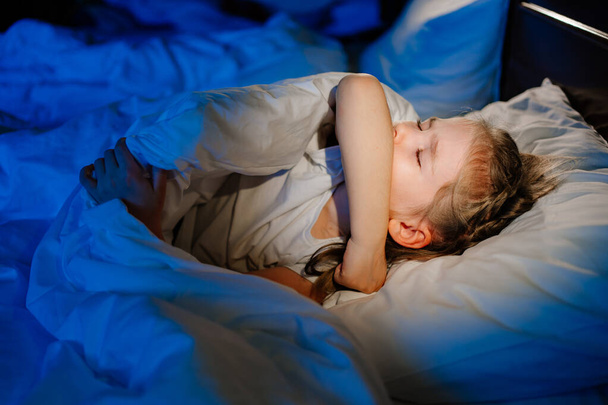 The little girl is sick, lies in bed and coughs. restless sleep during illness. - Fotoğraf, Görsel