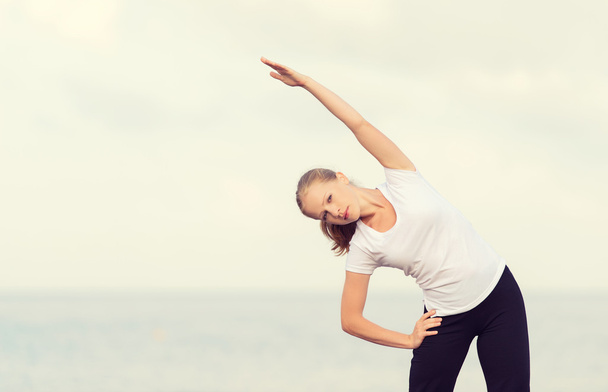 donna che fa yoga ed esercizi sportivi sulla spiaggia
 - Foto, immagini